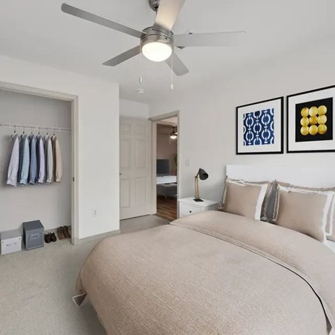 A bedroom with a large bed and a ceiling fan.